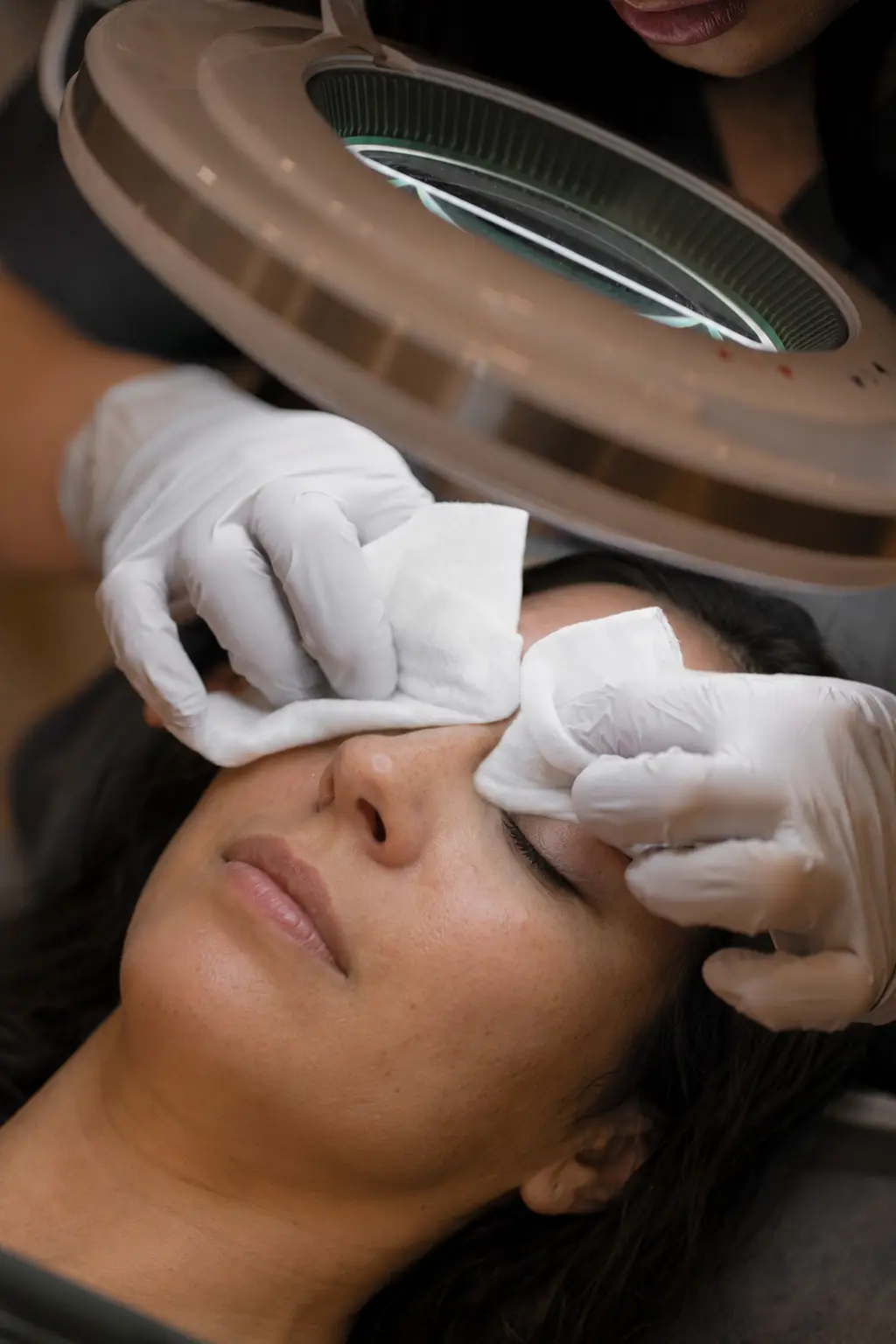 Close-up of a licensed esthetician performing a blackhead extraction under magnification at SI Glam Glow in Staten Island