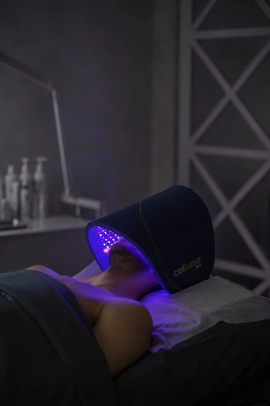 Client relaxing under the Celluma Pro LED light therapy device at SI Glam Glow in Staten Island