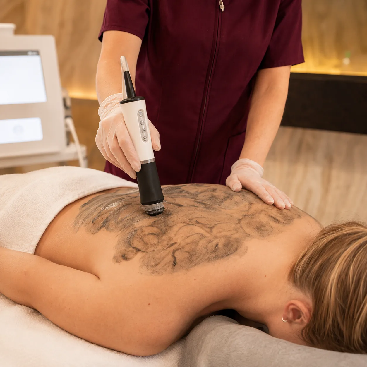 Licensed esthetician performing the oxygenating exfoliation step of a Glo2Back Facial at SI Glam Glow in Staten Island