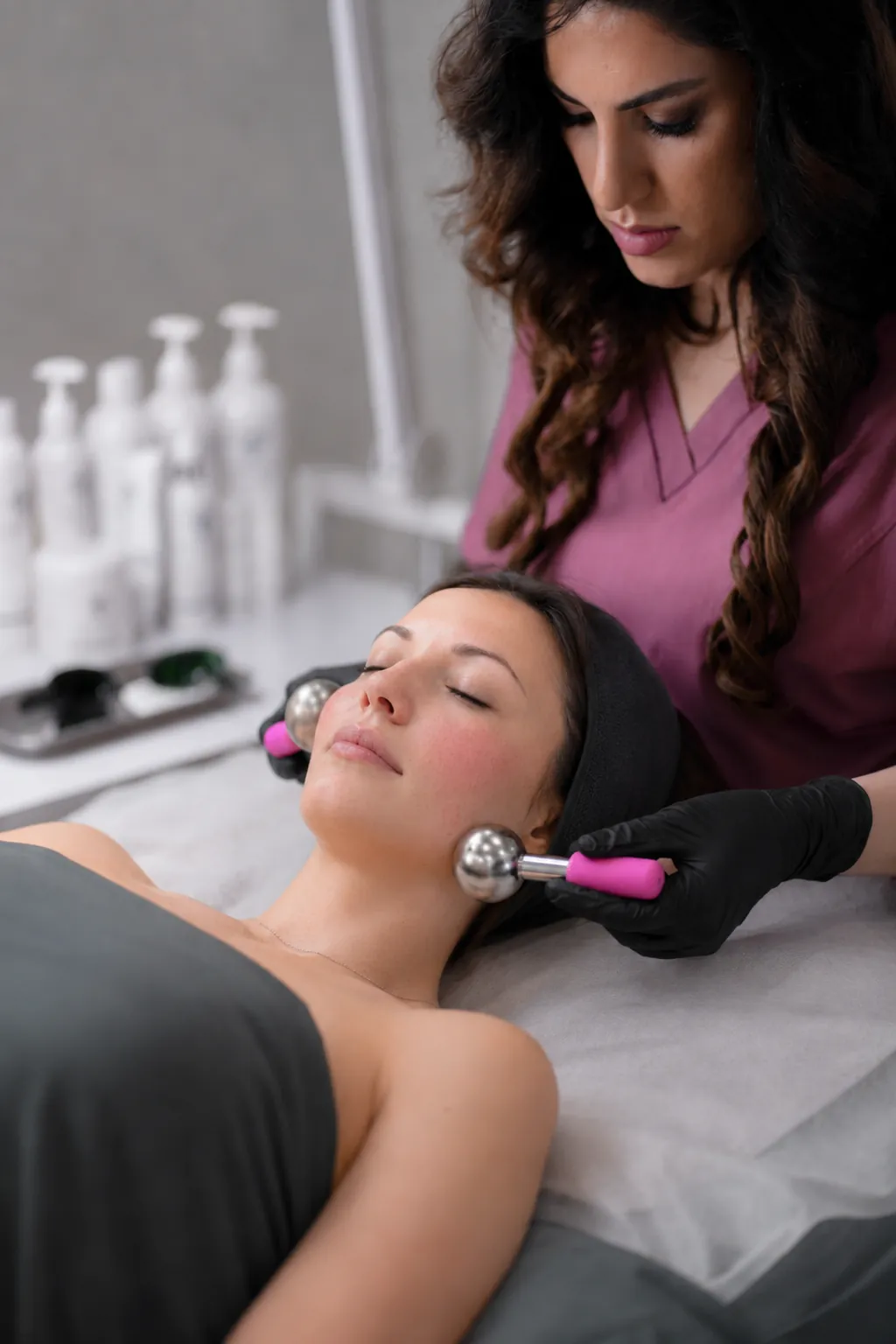 Licensed esthetician performing a Rosacea Rescue Facial with microcurrent probes at SI Glam Glow