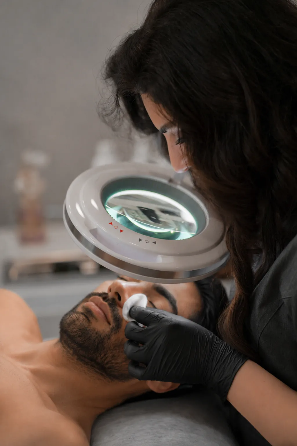 Close, careful extractions under a magnifying lamp during a Gentleman's Facial at SI Glam Glow